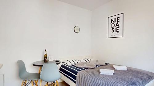 a bedroom with a bed and a table and chairs at Studio Fibra Gusto in Rybnik