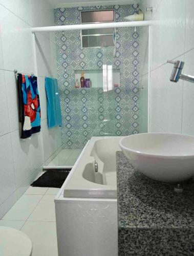 a white bathroom with a sink and a toilet at Recanto da Lú Casa - Salvador in Salvador