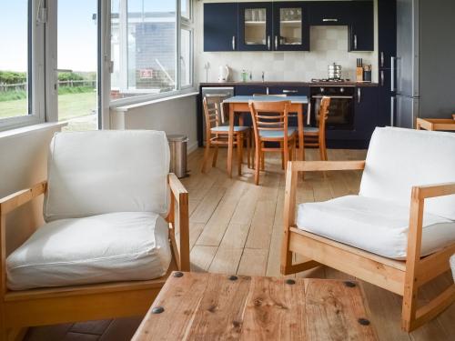 a kitchen and dining room with chairs and a table at Eastcliff Bungalow in Mundesley