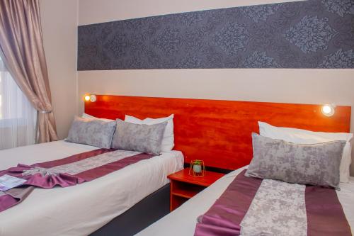 a hotel room with two beds and a table at Scenery Guesthouse Stadium in Maseru