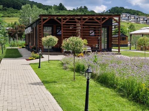 a wooden cabin in the middle of a garden at Georgia Tiny House - Hiperbara Livezeni Mures in Livezeni