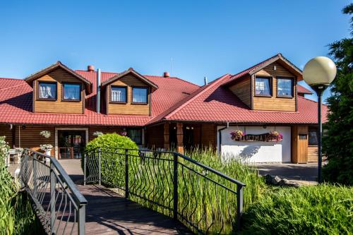 a house with a fence in front of it at Karczma Pod Topolami in Ratowo Piotrowo