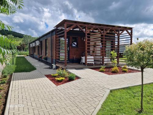 a small cabin with a pavilion in a garden at Georgia Tiny House - Hiperbara Livezeni Mures in Livezeni