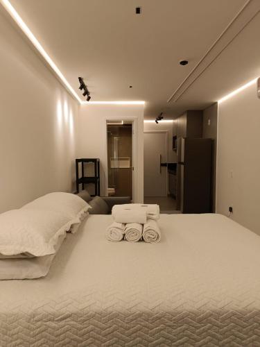 a bedroom with a bed with three towels on it at Beach Class Verano Flat 216 C in Porto De Galinhas