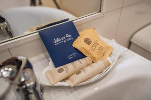 バルディビアにあるホテル マリーナ ヴィラ デル リオのシンクの上に本とトイレットペーパー2ロール