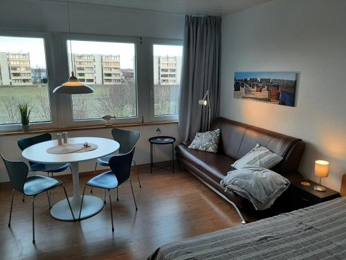 a living room with a couch and a table and a bed at Möwenhorst in Fehmarn