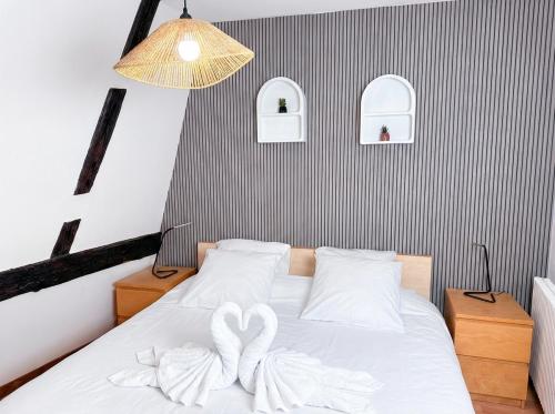 two hearts towels on a bed in a bedroom at Le Cocon Alsacien au cœur de Rouffach in Rouffach