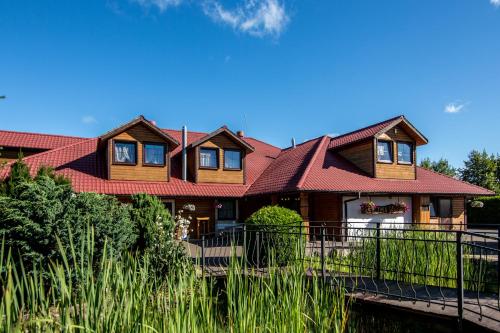 a large house with a red roof at Karczma Pod Topolami in Ratowo Piotrowo