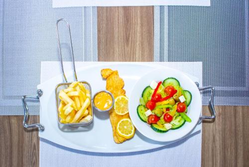 a plate of food with french fries and vegetables at Scenery Guesthouse Stadium in Maseru
