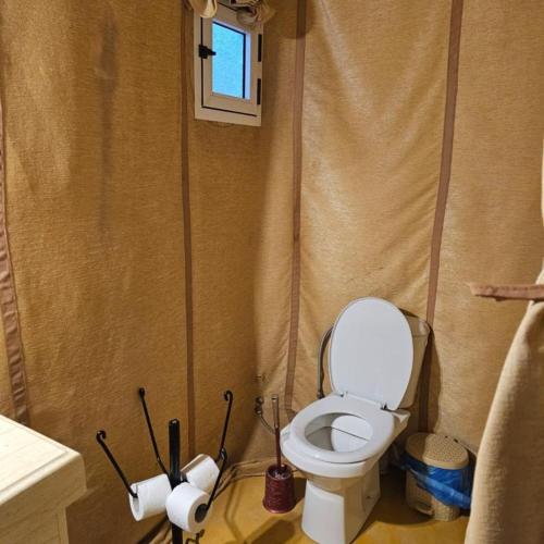 a bathroom with a toilet and two rolls of toilet paper at hagra luxury camp Merzouga in Merzouga