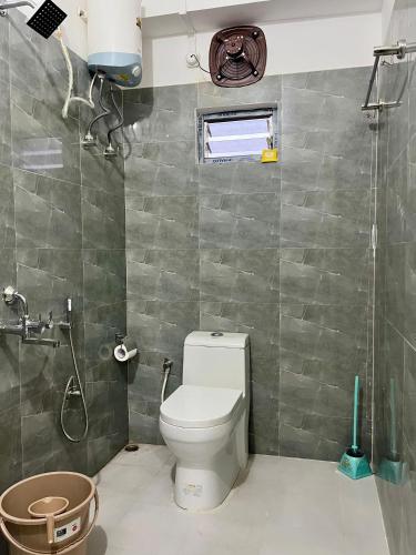 a bathroom with a toilet and a shower at Hotel Zirora in Ziro