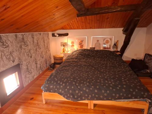 a bedroom with a large bed in a room with wooden ceilings at Les Mas d Olema in Puy-lʼÉvêque