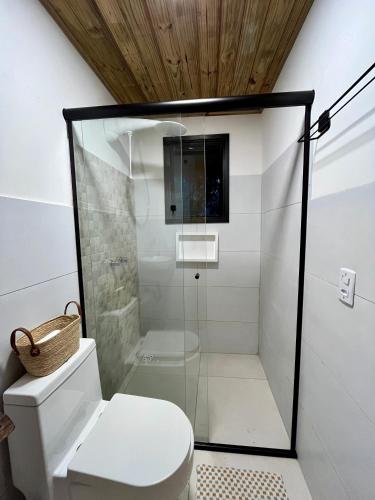 a bathroom with a glass shower with a toilet at Suíte em Trindade, Praia Brava, na Mata in Paraty