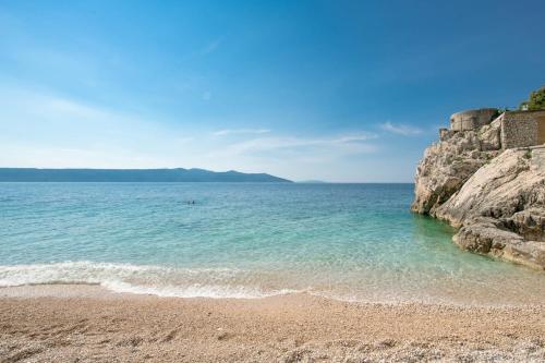a sandy beach next to a large body of water at Casa Nadia by Briskva in Mošćenička Draga