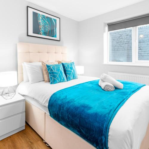 a white bedroom with a large bed with blue sheets at Modern 2 Bed Apartment - 2 Parking Spaces - Sleeps 3 - Netflix 1BS in Amblecote