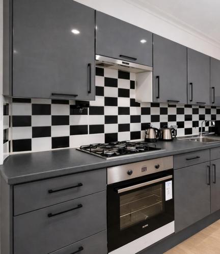 a kitchen with a black and white checkered wall at Evo Green Gravesend 2 bed Apartment, 2 mins Station, Town Centre in Gravesend
