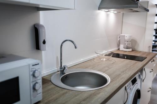 a kitchen counter with a sink in a kitchen at Apartamentos Cayetana in Badajoz