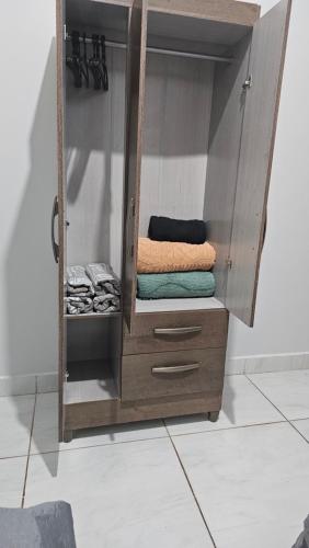 a wooden cabinet with towels in a room at Casa próxima à Praia do Cerrado e centro in Goianésia