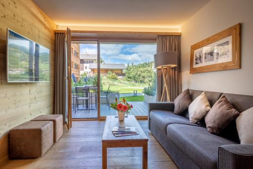 a living room with a couch and a table at SWISSPEAK Resorts by Pierre & Vacances Premium Vercorin in Vercorin