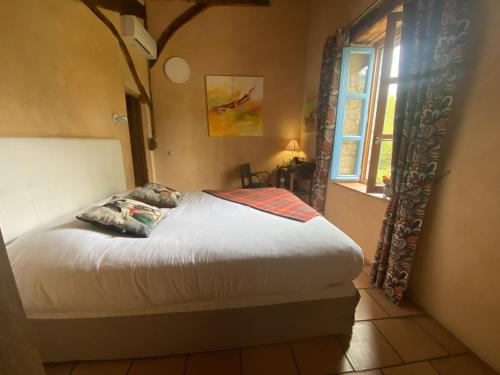 a bedroom with a bed and a window at LE CLOS PASTEL Chambres d'hôtes et son studio suite - ADULTES ONLY in Virac