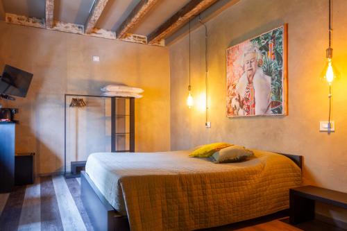a bedroom with a bed and a painting on the wall at Dimora Del Teatro in Vigevano
