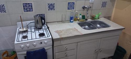 a kitchen with a stove and a sink at La Arbolada in Mar del Plata