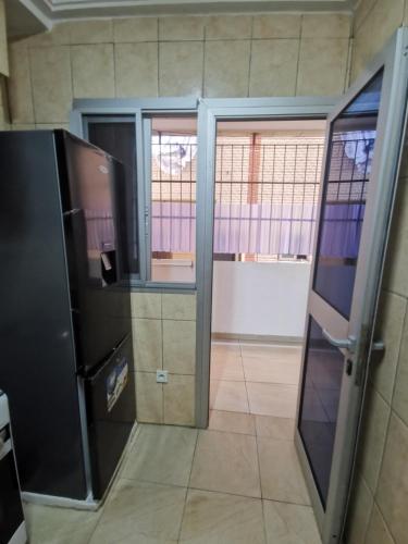 an open door to a room with a refrigerator at Studio VIP - Bonamoussadi - Groupe électrogène - 2douches in Douala