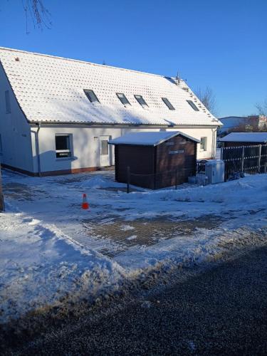 a white house with a shed in the snow at Haus Astrid -Schwerin-Görries - in Klein Rogahn
