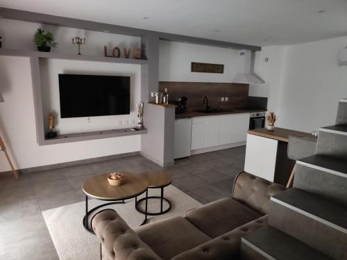 a living room with a couch and a table at La chambre des tentations , love room avec jacuzzi in Bages