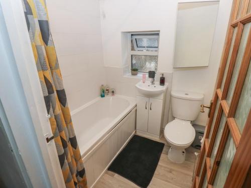 a bathroom with a tub and a toilet and a sink at Chestnut Lodge in Bradford