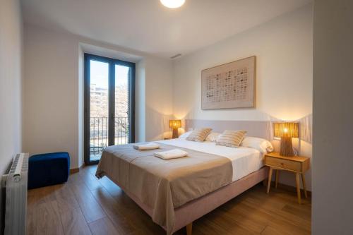a bedroom with a bed with two towels on it at Modern apartments in one building, in the heart of Girona in Girona
