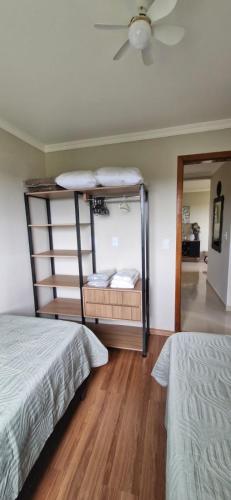 a bedroom with two beds and a ceiling fan at Apartamento inteiro in Ponta Grossa