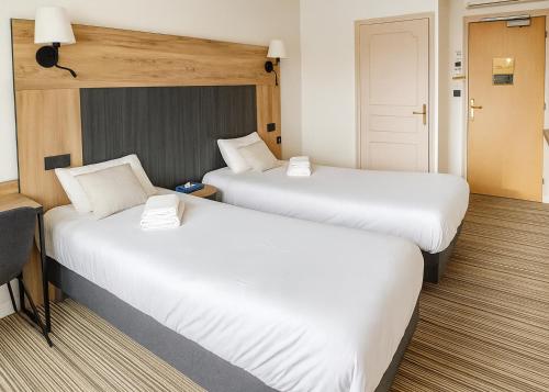 two beds in a hotel room with white sheets at The Originals City, Hôtel Napoléon, La Roche-sur-Yon in La Roche-sur-Yon