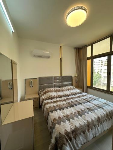 a bedroom with a bed and a large window at Darona Apartments - Nablus in Nablus