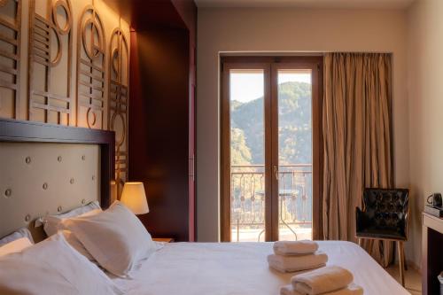 a bedroom with a bed with two towels on it at Lagadia 4 Seasons Hotel in Lagkadia