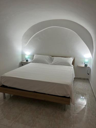 a bedroom with a large bed with an arch overhead at Il vicoletto in Sulmona