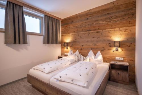 a bedroom with a bed with a wooden wall at Appart Christophorus in Söll