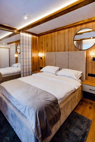 a bedroom with a large bed and a mirror at Celeste Luxury Apartments in Ranca