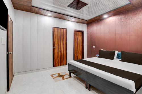 a bedroom with a large bed and a wooden wall at Hotel O NICE HOTEL in Faridabad
