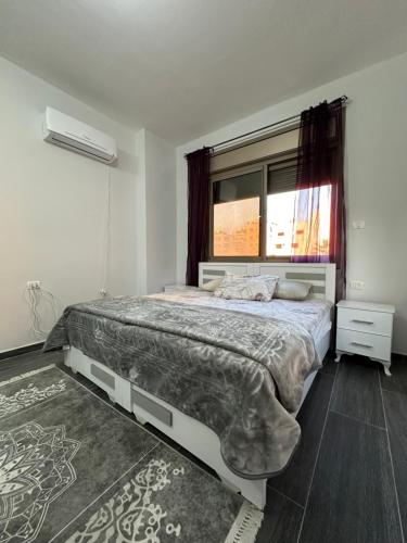a bedroom with a large bed and a window at Darona Apartments - Nablus in Nablus
