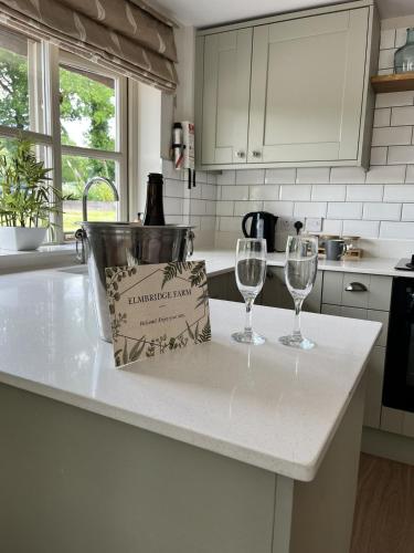 two wine glasses and a bag on a kitchen counter at LODGE Nuthatch in Droitwich