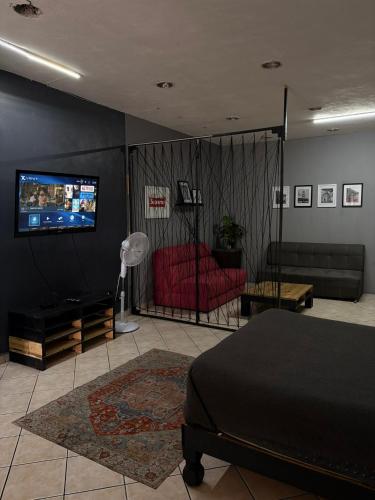 a living room with a couch and a tv on a wall at Departamento en el corazón de Zamora, a 2 cuadras del Santuario Guadalupano in Zamora de Hidalgo