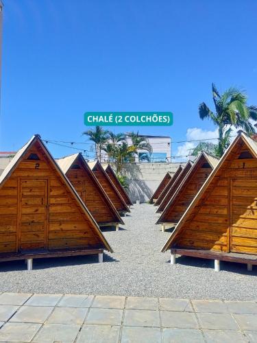 a row of wooden beach huts on the beach at Hostel Costa Terral in Matinhos