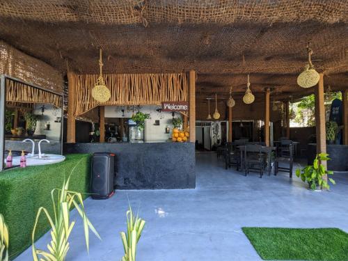 a restaurant with a bar and a table and chairs at Secret Surf Hostel in Weligama
