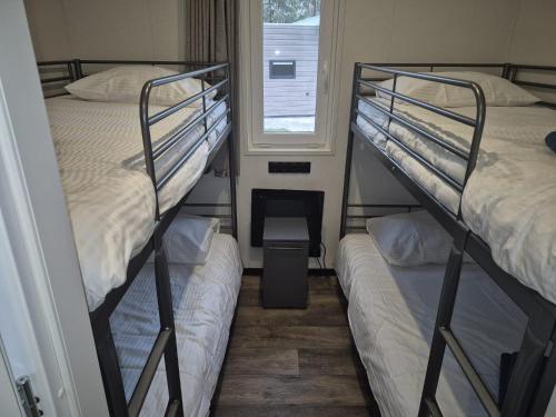 two bunk beds in a room with a window at Casa Sallandia met Outdoor Wellness! in Haarle