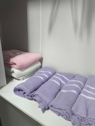 a row of purple towels sitting on a shelf at Sobrado há 7 quadras da praia in Matinhos