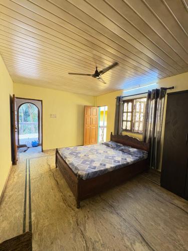 a bedroom with a bed and a ceiling fan at Virens Heaven Stays in Calangute