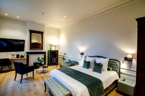 a bedroom with a bed and a chair and a desk at St-Georges IV in Ieper