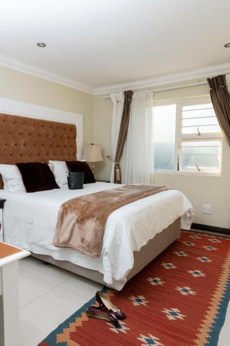 a bedroom with a large bed and a large window at Dikalo Highston in Johannesburg