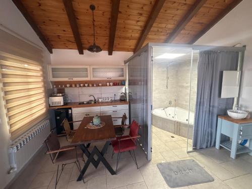 a kitchen with a table and a bath tub at Alpinia in Majdal Shams